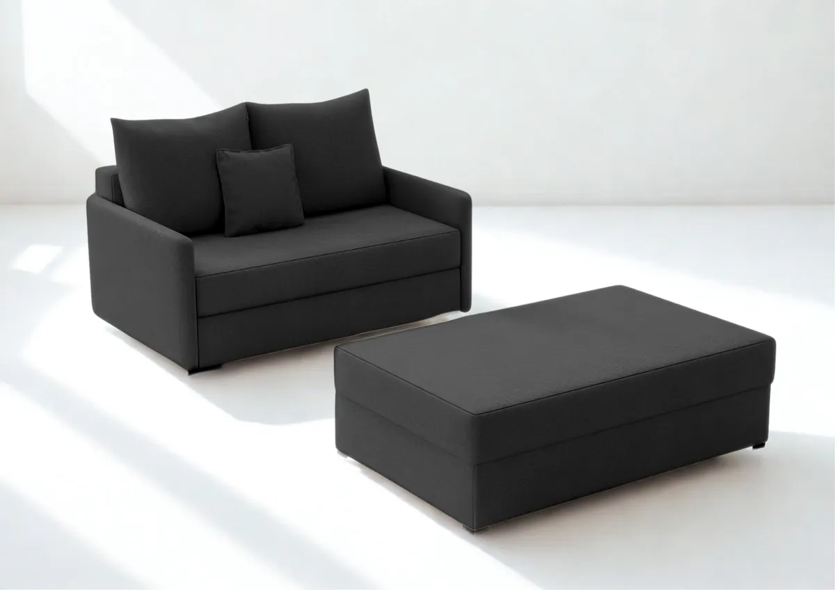 Sofa czarna ARKADIA z funkcją spania z pufą 130 cm: Czarna sofa ARKADIA